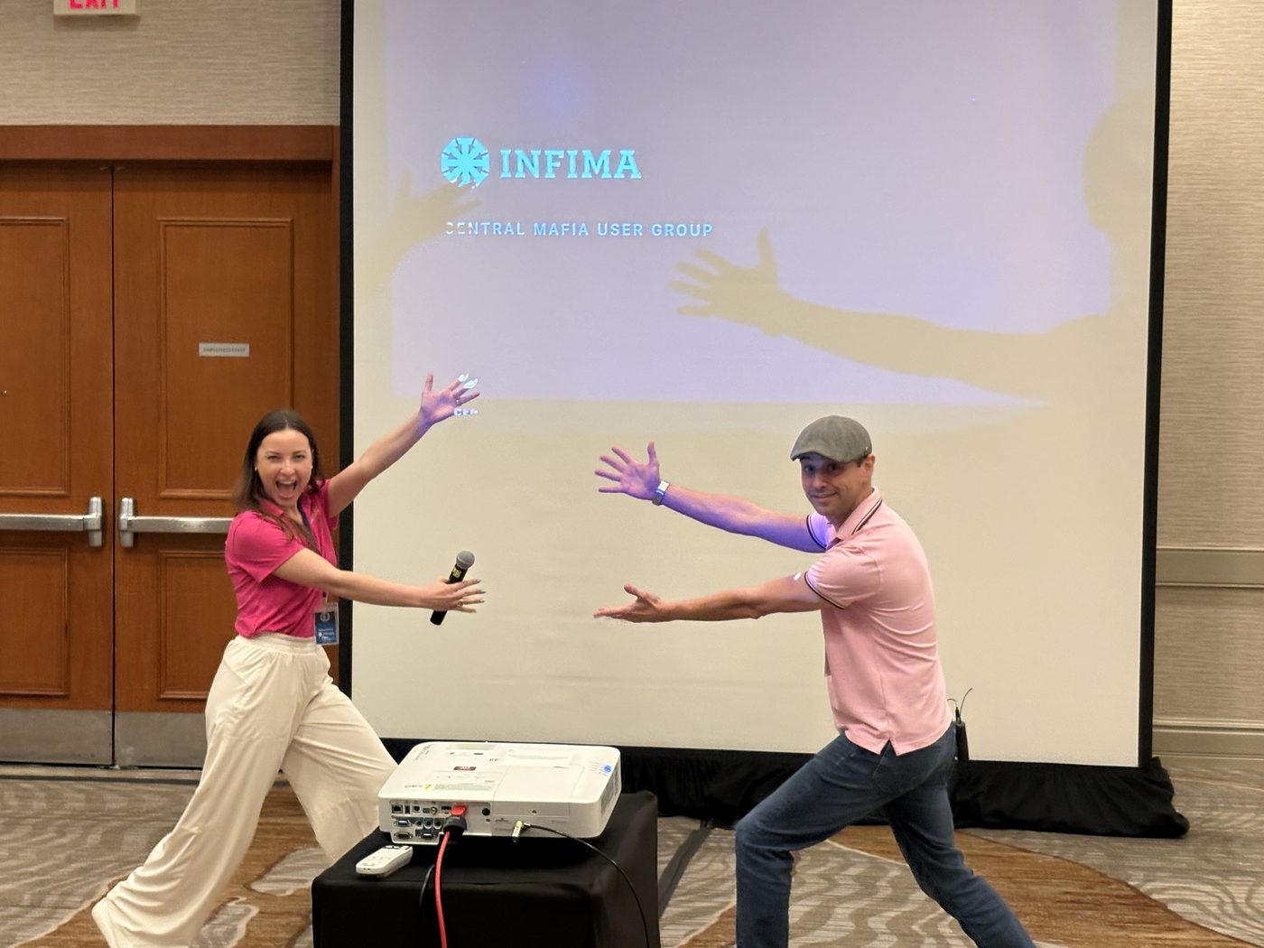 Two CMUG presenters strike a hero pose during a session, showing the community's playful spirit