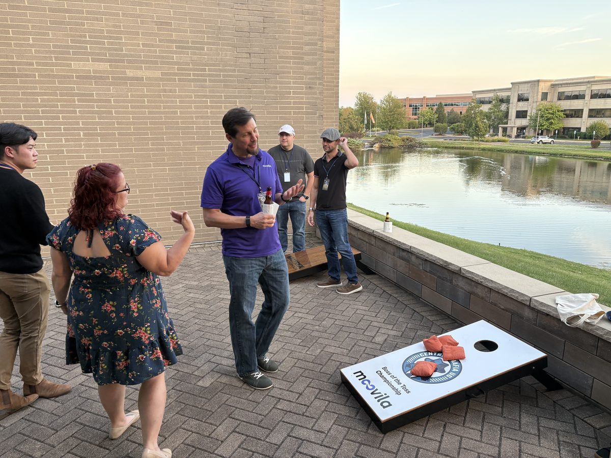 CMUG attendees playing cornhole at sunset during the evening networking session